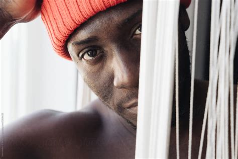 Portrait Of Black Man Looking Through The Curtain By Stocksy