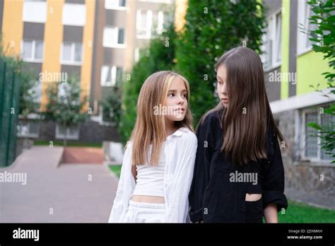 Fraternal Twins Sisters Blonde And Brunette Teen Girls In Fashionable Black And White Clothes
