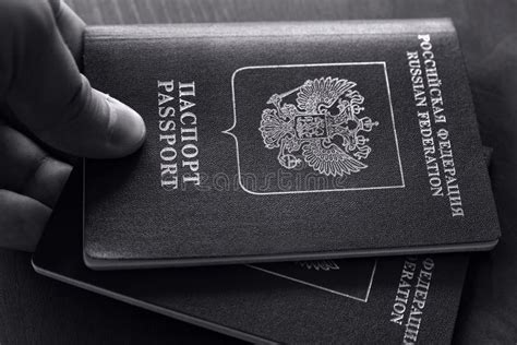 Closeup Of Man Holding Two Red Passports Black And White Photo Stock