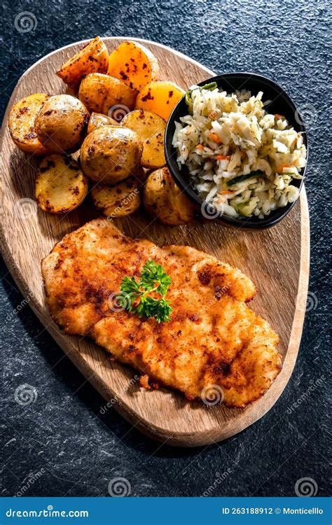 Chuleta De Pollo Recubierto De Migas De Pan Con Patatas Y Col Foto De