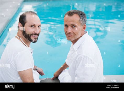 Gay Couple Dangling Feet In Swimming Pool Stock Photo Alamy