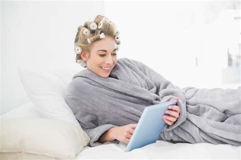 Premium Photo Charming Relaxed Blonde Woman In Hair Curlers Using A