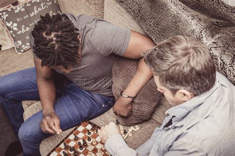 Un Par Gay Que Disfruta De Tiempo Dentro En Casa Jugando A Ajedrez Foto De Archivo Imagen De