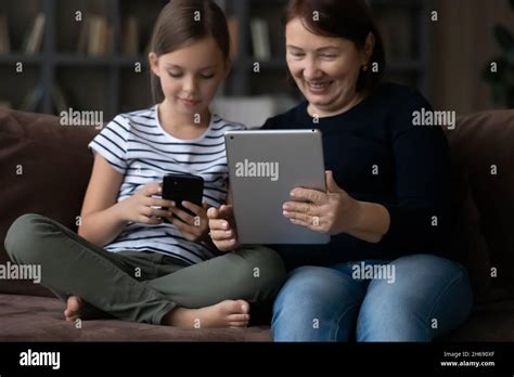Happy Mature Grandmother With Granddaughter Using Modern Devices Together Stock Photo Alamy