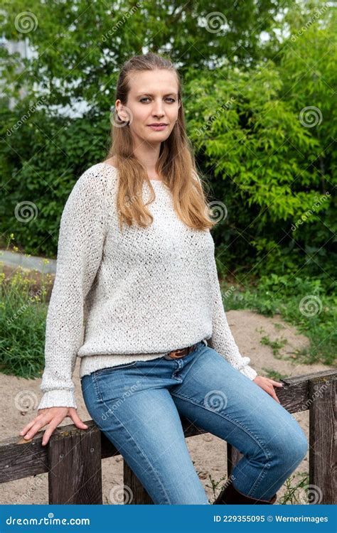 Sch Ne Junge Blonde Frau Sitzt Drau En Auf Zaun Und L Chelt Stockbild Bild Von Einsam Portr T