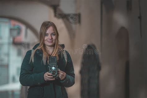 La Femme Du Caucase Blonde Sexy Tient Une Caméra De Photographies D époque Dans Une Ruelle