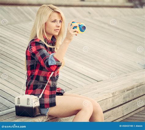 Attraktive Blonde Frau Sitzend Auf Dem Bretterboden Und Mit Einer Spielzeugkamera Fotografiert
