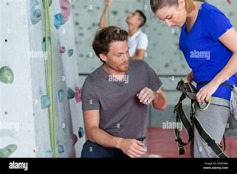 Woman Attaching Harness Prior To Climbing Indoor Wall Stock Photo Alamy