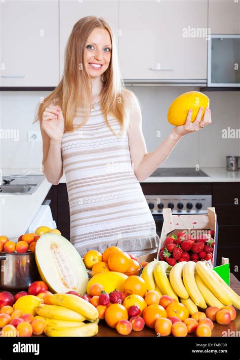 Blonde Long Haired Woman With Melon And Heap Of Fruits Stock Photo Alamy