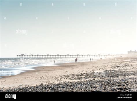 People Walking On Emerald Isle Beach W Bogue Pier In Distance On A