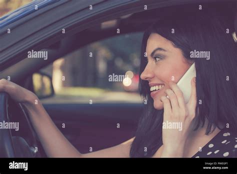 Side View Of Brunette Speaking On Phone While Driving Car Cheerfully