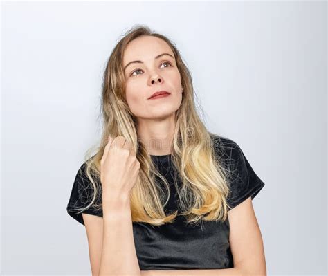 Portrait Of Dreamy Blonde Woman With Long Hair In Black Top Hand Near Her Hair Stock Image
