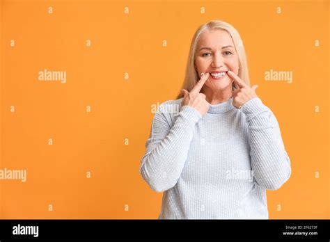 Happy Mature Woman With Beautiful Smile On Color Background Stock Photo