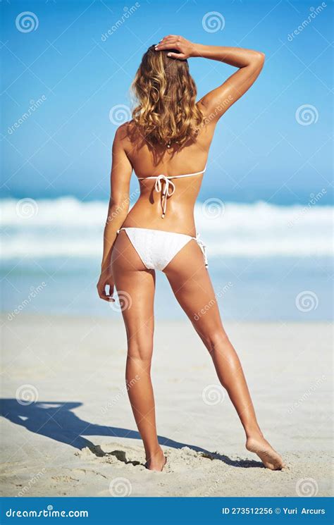 Rociando Su Cuerpo De Verano Captura De Pantalla De Una Preciosa Joven En Un Bikini En La Playa