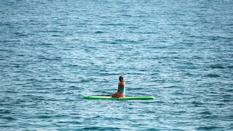 mar mulher e aí silhueta do feliz positivo jovem mulher dentro azul bikini surfar em verde sup