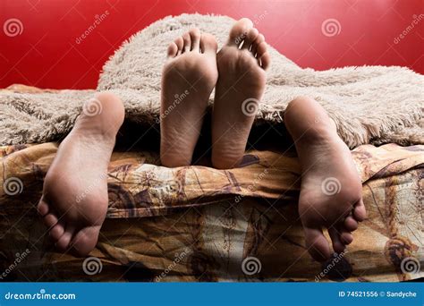 Two Pairs Of Male And Female Feet Seen From Under The Blanket Sleep Together Lovers Having Sex