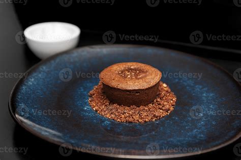 Chocolate Volcano Dessert On A Blue Plate Next To Ice Cream On A Black