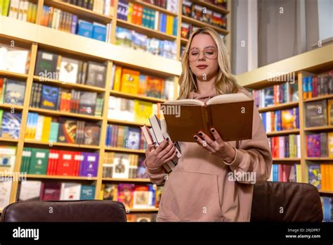 Pretty Blonde Woman Standing With Books In Library Stock Photo Alamy