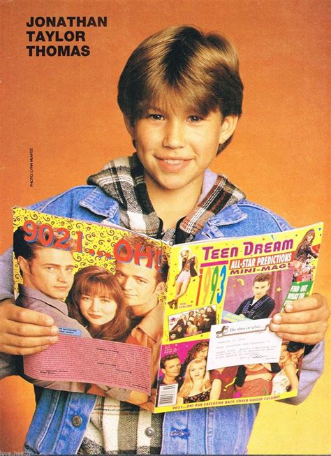 a young boy is holding two books in his hands