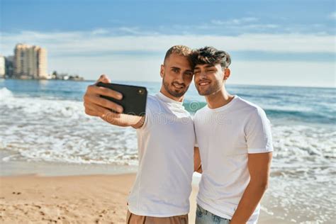 Jovem Casal Gay Sorrindo Feliz Fazendo Selfie Pelo Smartphone Na Praia Foto De Stock Imagem De