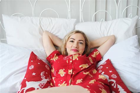 Schöne Blonde Mädchen in Roten Schlafanzügen Liegt Auf Dem Bett Lächelt Und Schaut Auf