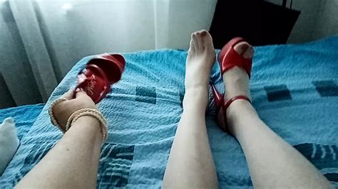 Milf Transe zeigt nur ihre Beine in weißen transparenten Strumpfhosen und simuliert Footjob mit