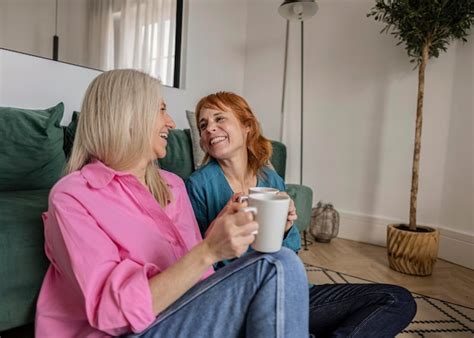 Um Casal Gay L Sbico Adulto Sentado No Ch O De Sua Sala De Estar Olhando Um Para O Outro