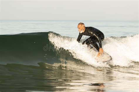 Stunning View Of A Mature Surfer Catches A Wave Stock Photo Image Of Active Lifestyle