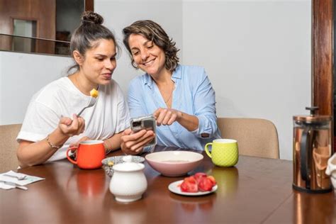 Una Pareja Gay Desayunando Mientras Miran El M Vil Y Se R En Juntos Foto Premium