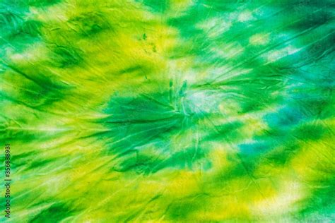 Yellow Green Spiral Tie Dye Background On Fabric Flat Lay Stock Photo