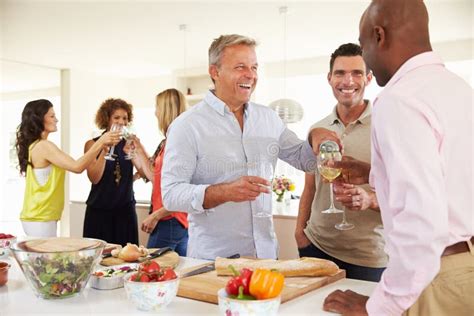 Group Of Mature Friends Enjoying Dinner Party At Home Stock Photo Image Of Fifties