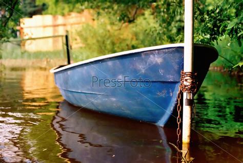 Фотография на тему Прогулочный катер, привязанный к столбу | PressFoto