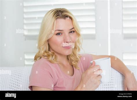 Happy Blonde Relaxing On The Couch With A Coffee Stock Photo Alamy