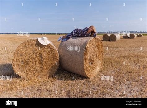 Une Jeune Fille Blonde Aux Cheveux Longs Dans Un Chapeau Blanc Se Repose Et Pose Pr S Des Gerbes