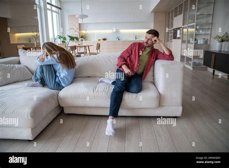 Upset Unhappy Crying Wife Sitting On Sofa Turning Back To Indifferent