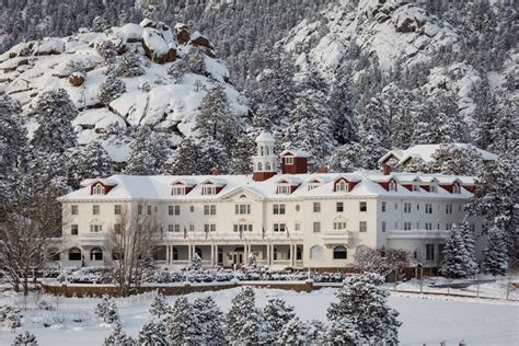 a large white building surrounded by snow covered trees