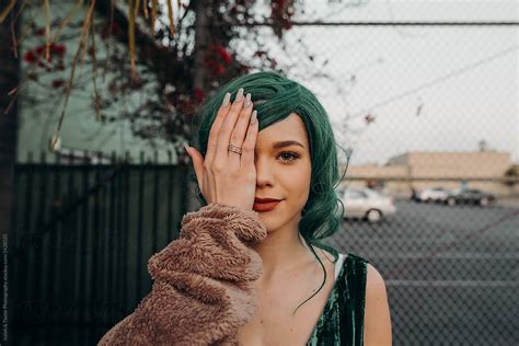 Woman Smiling At Camera Covering Half Of Her Face With Glamorous Fake