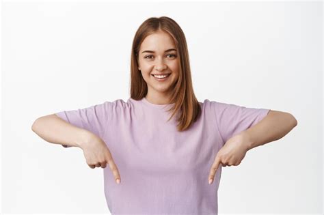 Portrait En Gros Plan D Une Fille Blonde Souriante Pointant Les Doigts Vers Le Bas L Air