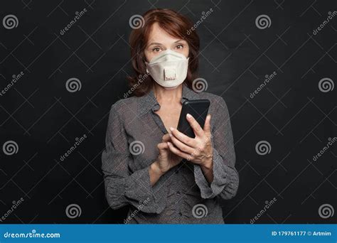 Mature Business Woman In Medical Mask Using Smartphone On Black