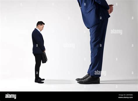 Giant Boss And Sad Small Man On Light Background Stock Photo Alamy