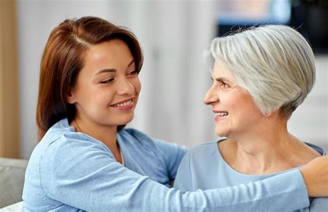 Premium Photo Senior Mother With Adult Daughter Hugging At Home