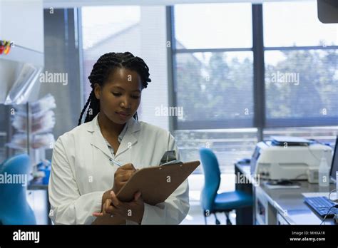 Female Scientist Writing On Clipboard Stock Photo Alamy