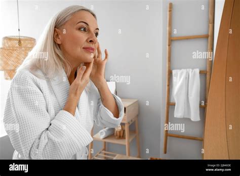 Morning Of Mature Woman Giving Herself Facial Massage At Home Stock Photo Alamy