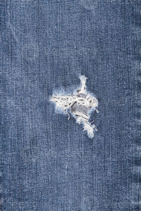 vertical image hole  threads  denim jeans ripped destroyed torn