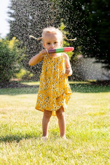Premium Photo A Little Girl In A Yellow Dress With Flowers On Her