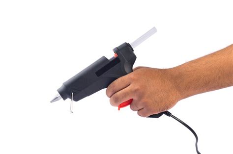 Premium Photo Hand Holding Electric Hot Glue Gun Isolated