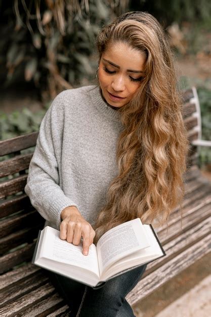 Blonde jeune femme lisant un livre à l extérieur Photo Gratuite