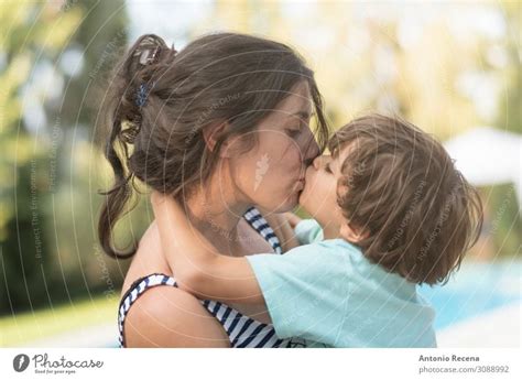 Mother Kissing Son In Garden Outdoors Images A Royalty Free Stock