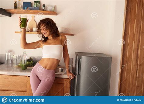 Woman Drinking Green Detox Juice Smoothie Drink In Kitchen Stock Image