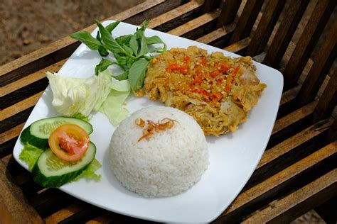 Premium Photo | Nasi ayam geprek. sambal lalap. is rice with a side
